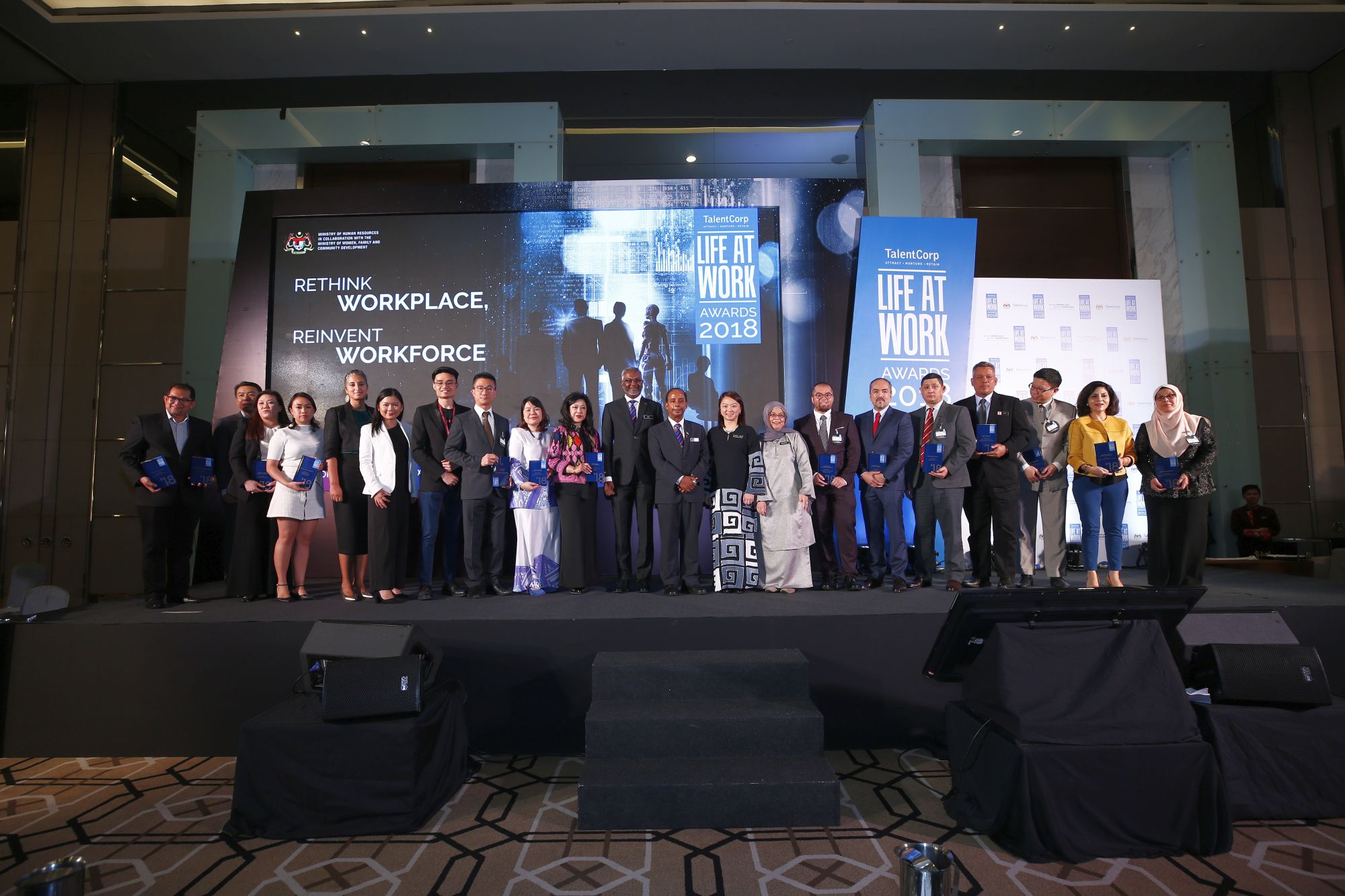 The LIFE AT WORK 2018 winners standing proudly on stage.